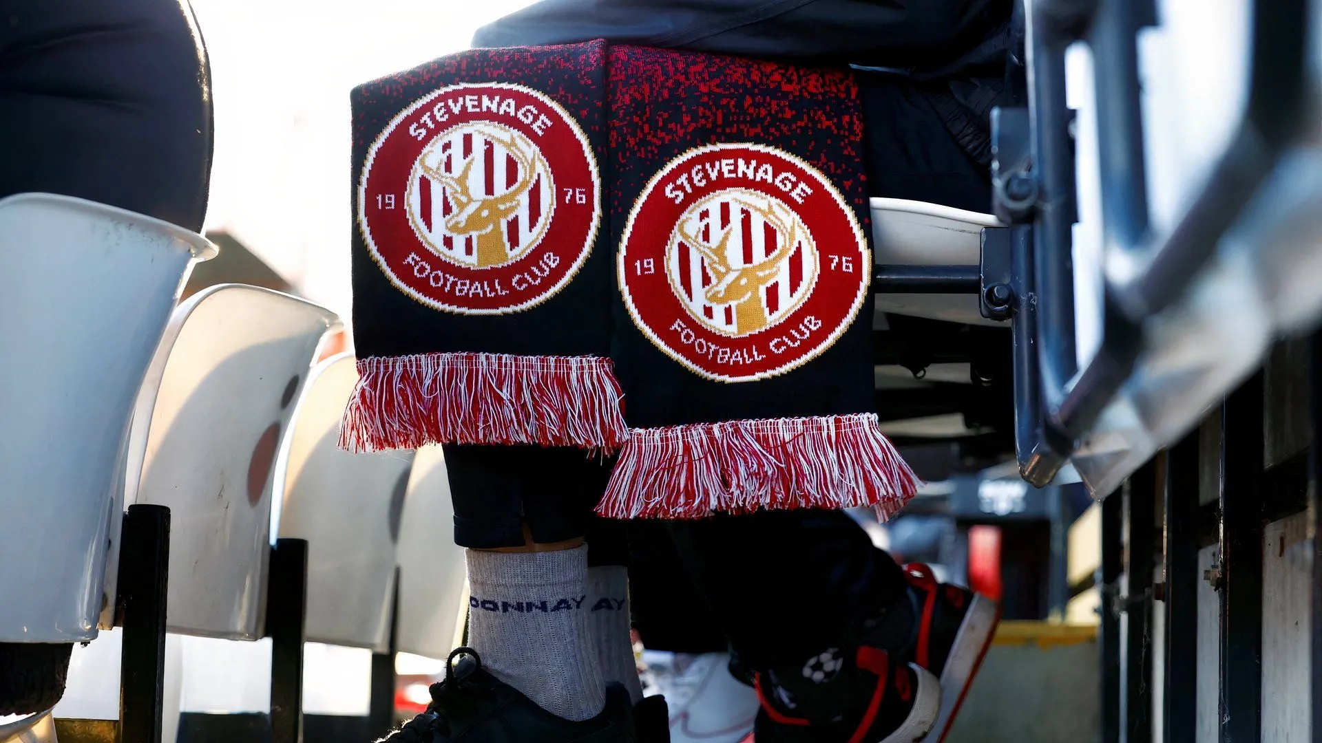 Cổ động viên Stevenage trên khán đài, tượng trưng cho áp lực thành tích và kỳ vọng mua sắm của CLB